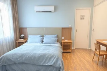 Kamar kos minimalis dengan spring bed, meja belajar, AC, dan lantai vinyl.